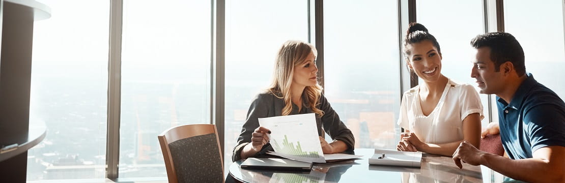 Couple sits at a table with a financial advisor