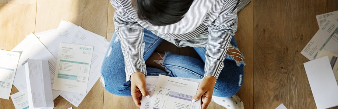 Bird's eye view of person sitting on floor reviewing documents.